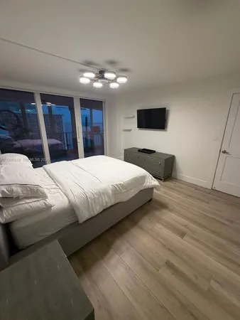 a bedroom with a bed and a flat screen tv