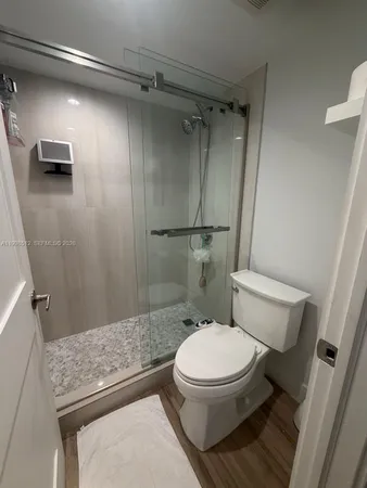 a bathroom with a granite countertop toilet and a shower