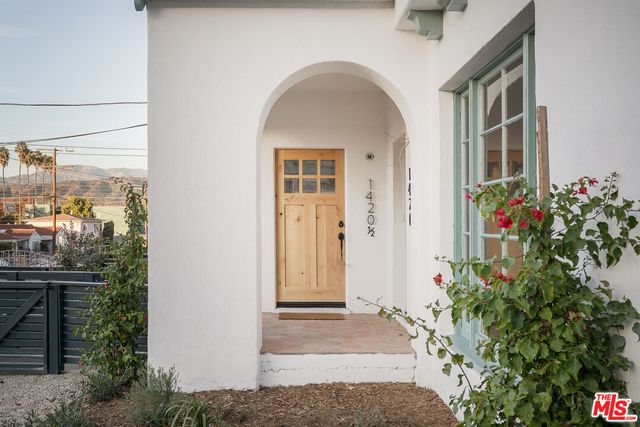 a view of a brick house with potted plants
