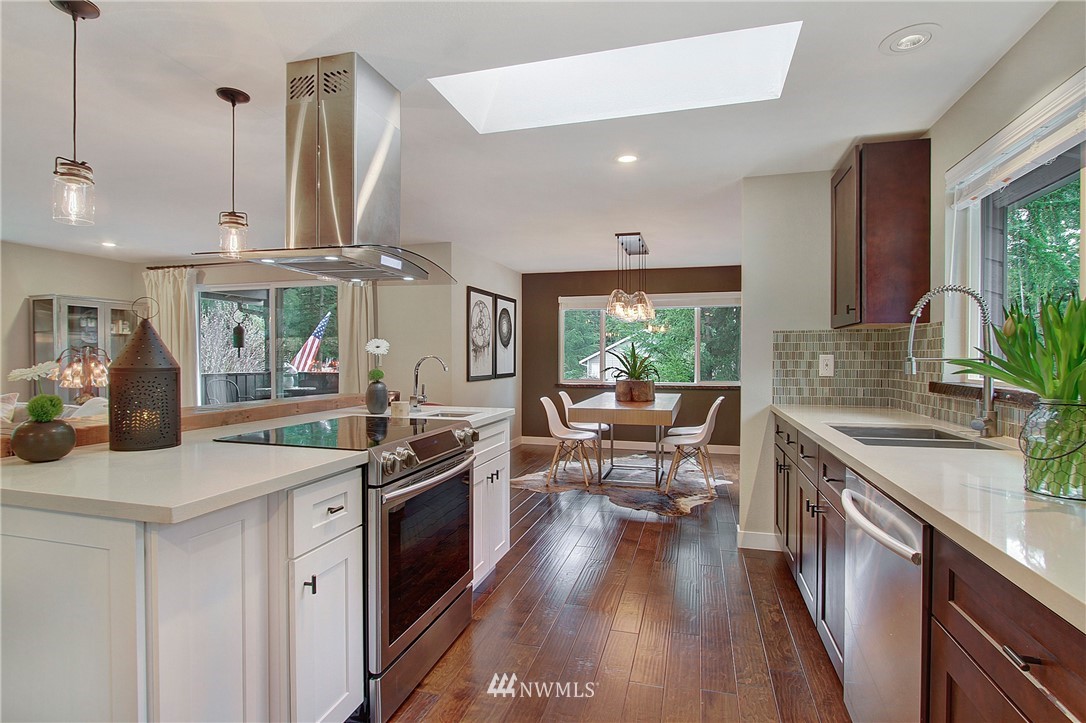 15003 Southeast 138th Place Renton, WA 98059 - Photo 6 of 38 a kitchen with stainless steel appliances granite countertop a sink a stove and a wooden floors