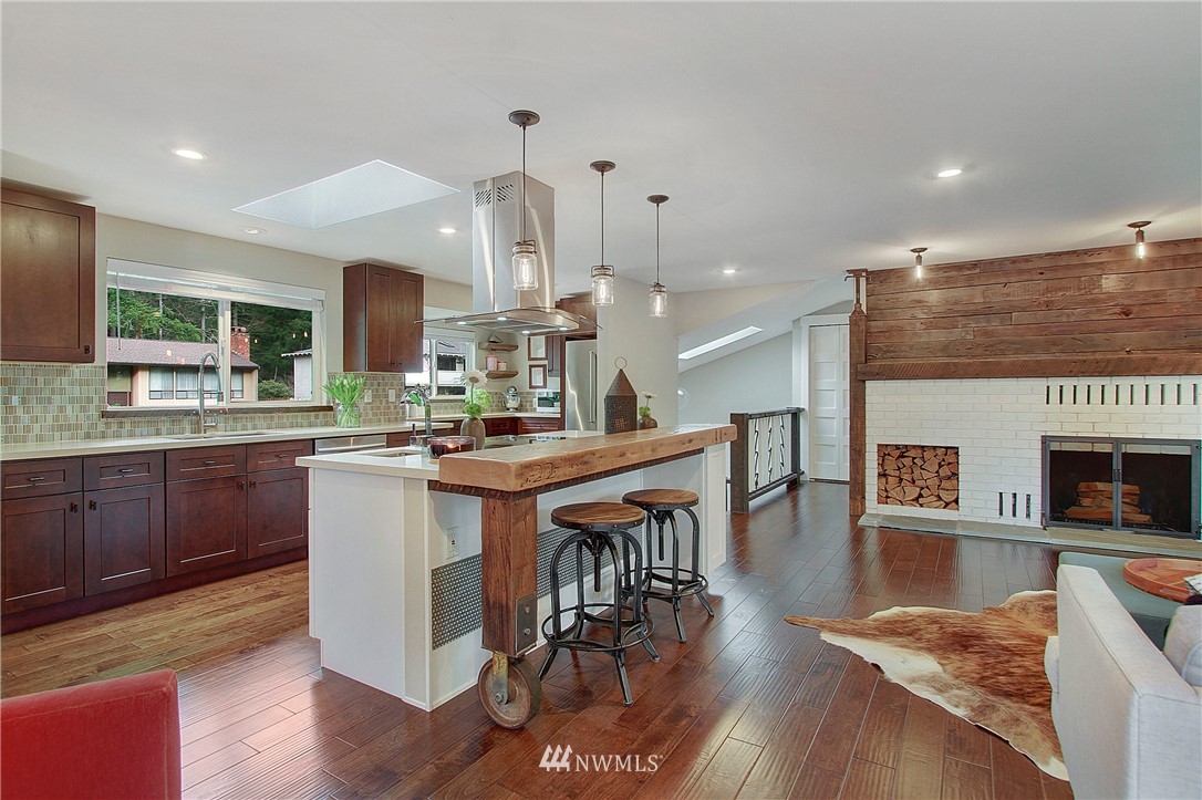 15003 Southeast 138th Place Renton, WA 98059 - Photo 9 of 38 a kitchen with stainless steel appliances kitchen island granite countertop a table chairs sink and cabinets