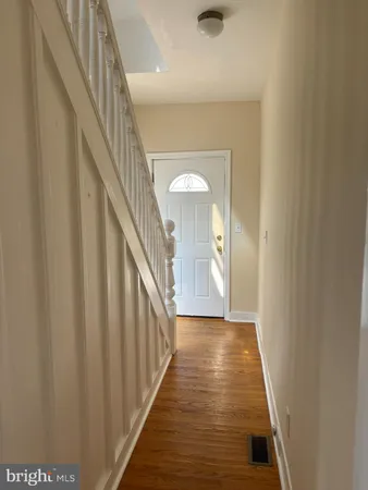 a view of a hallway with wooden floor and staircase