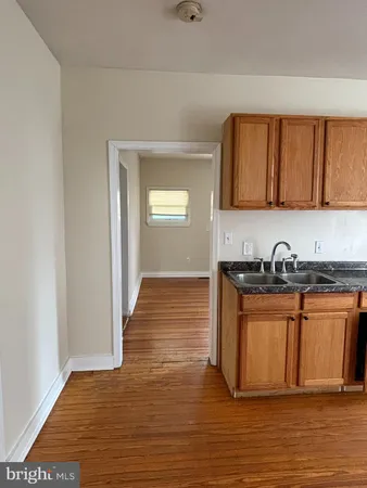 a view of kitchen with granite countertop cabinets and wooden floor