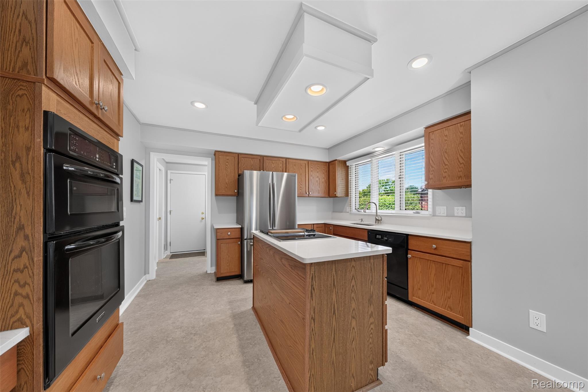 1236 Chaffer Drive Rochester, MI 48306 - Photo 14 of 76 Kitchen featuring wood-finish cabinetry, a center island with a white countertop, recessed lighting, and a stainless steel refrigerator