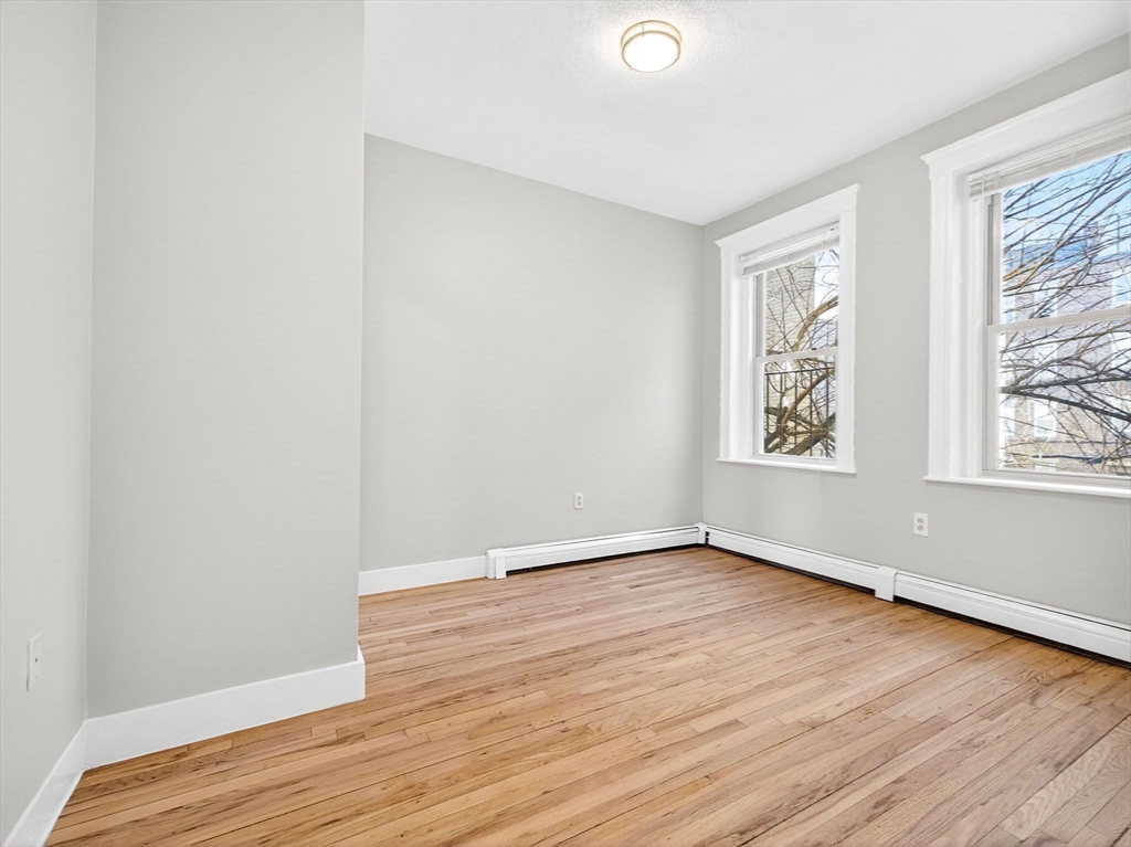 12 Ransom Road, Unit 7 Boston, MA 02135 - Photo 12 of 25 an empty room with wooden floor and windows