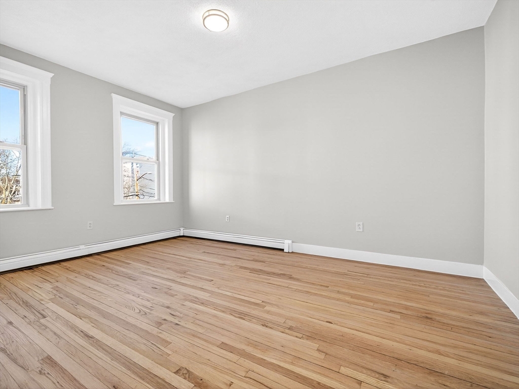 12 Ransom Road, Unit 7 Boston, MA 02135 - Photo 6 of 25 a view of an empty room with wooden floor and a window