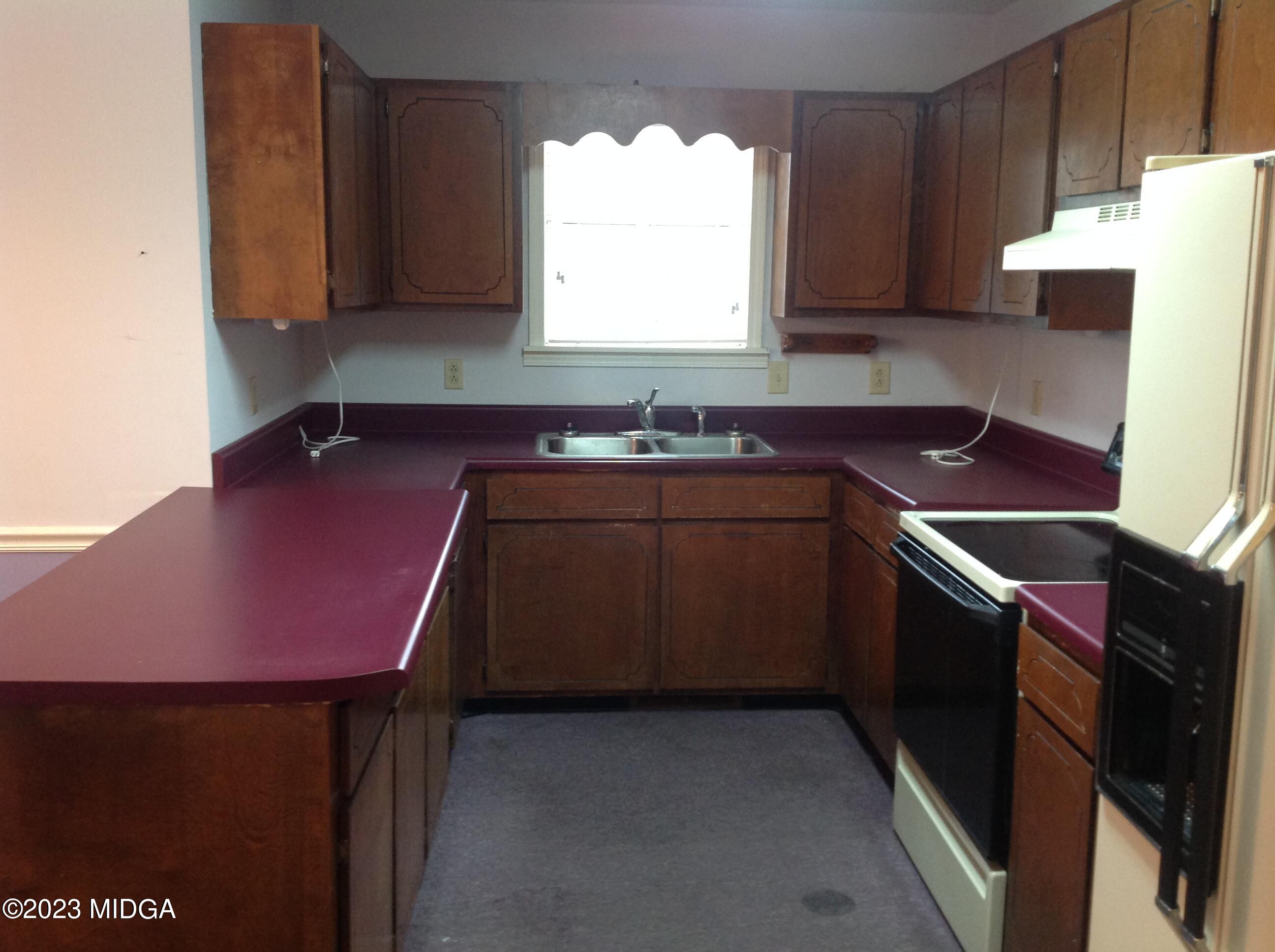 6251 Columbus Road Macon, GA 31206 - Photo 7 of 33 a kitchen with a sink stove and cabinets