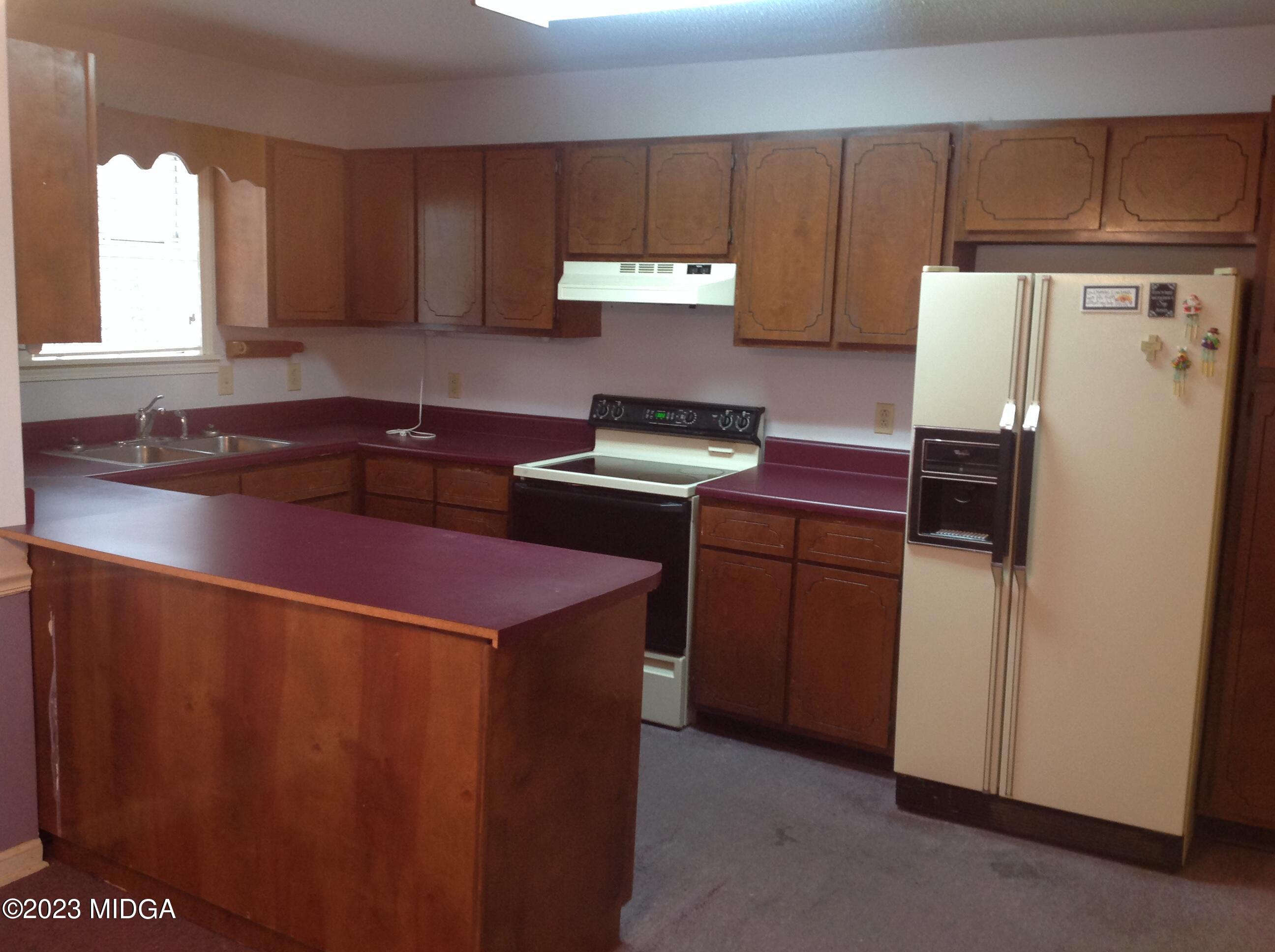 6251 Columbus Road Macon, GA 31206 - Photo 9 of 33 a kitchen with a refrigerator and a stove