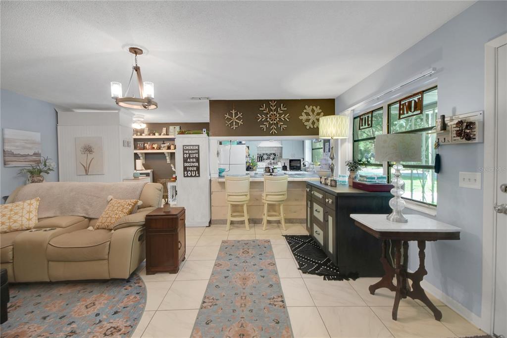 6122 East Glencoe Street Inverness, FL 34452 - Photo 6 of 37 a living room with furniture a fireplace and a chandelier