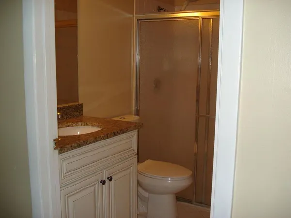 a bathroom with a granite countertop sink and toilet