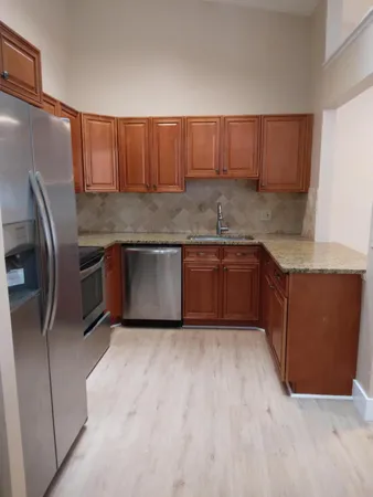 a kitchen with stainless steel appliances granite countertop a sink and a refrigerator