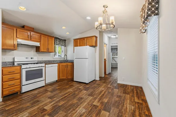 a kitchen with wooden floors and white appliances