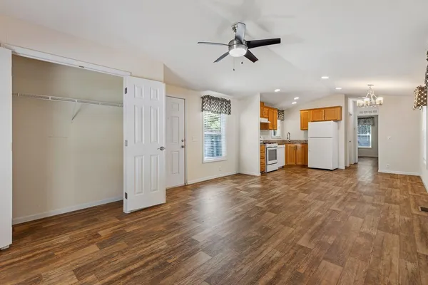a view of a kitchen with a refrigerator wooden floor and a ceiling fan