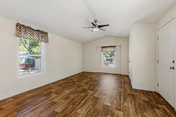 a view of an empty room window and wooden floor