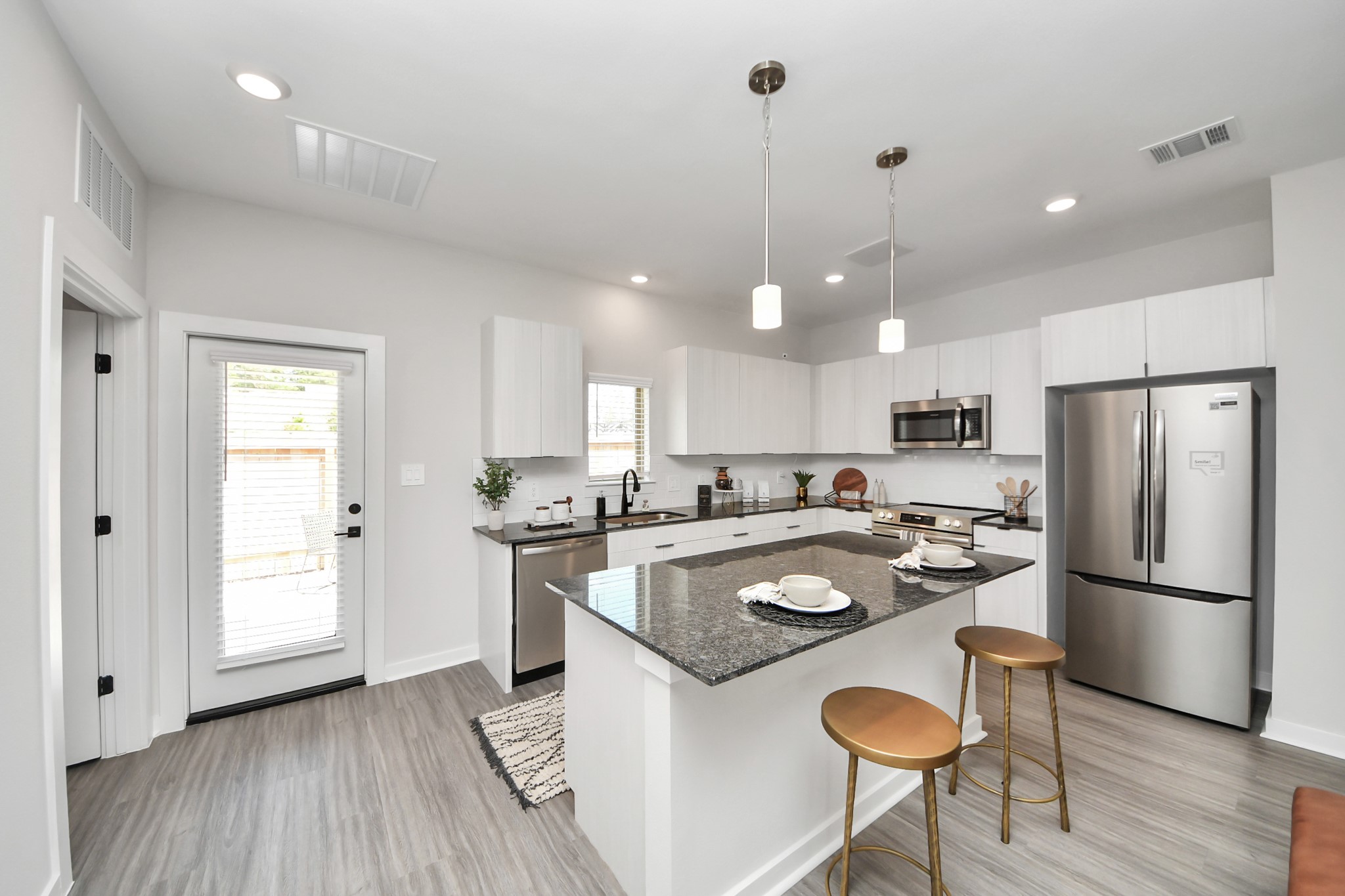 7711 Longmire Road, Unit 2 Conroe, TX 77304 - Photo 43 of 48 Boasting luxury finishes-stylish Island kitchen,granite counters,subway tile backsplash,ample custom cabinet space,stainless appliances,refrigerator,full size washer&dryer included,wood-like flooring throughout,open concept floor plan.