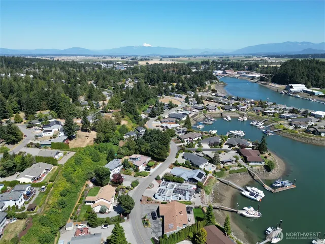 an aerial view of a city with lots of residential buildings and ocean view in back