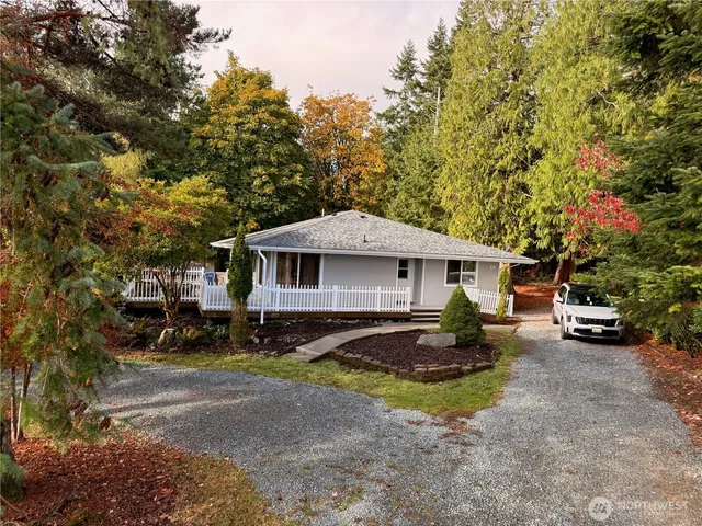 a front view of a house with a yard and trees