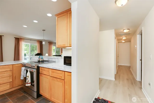 a kitchen with stainless steel appliances granite countertop a sink a stove and a refrigerator