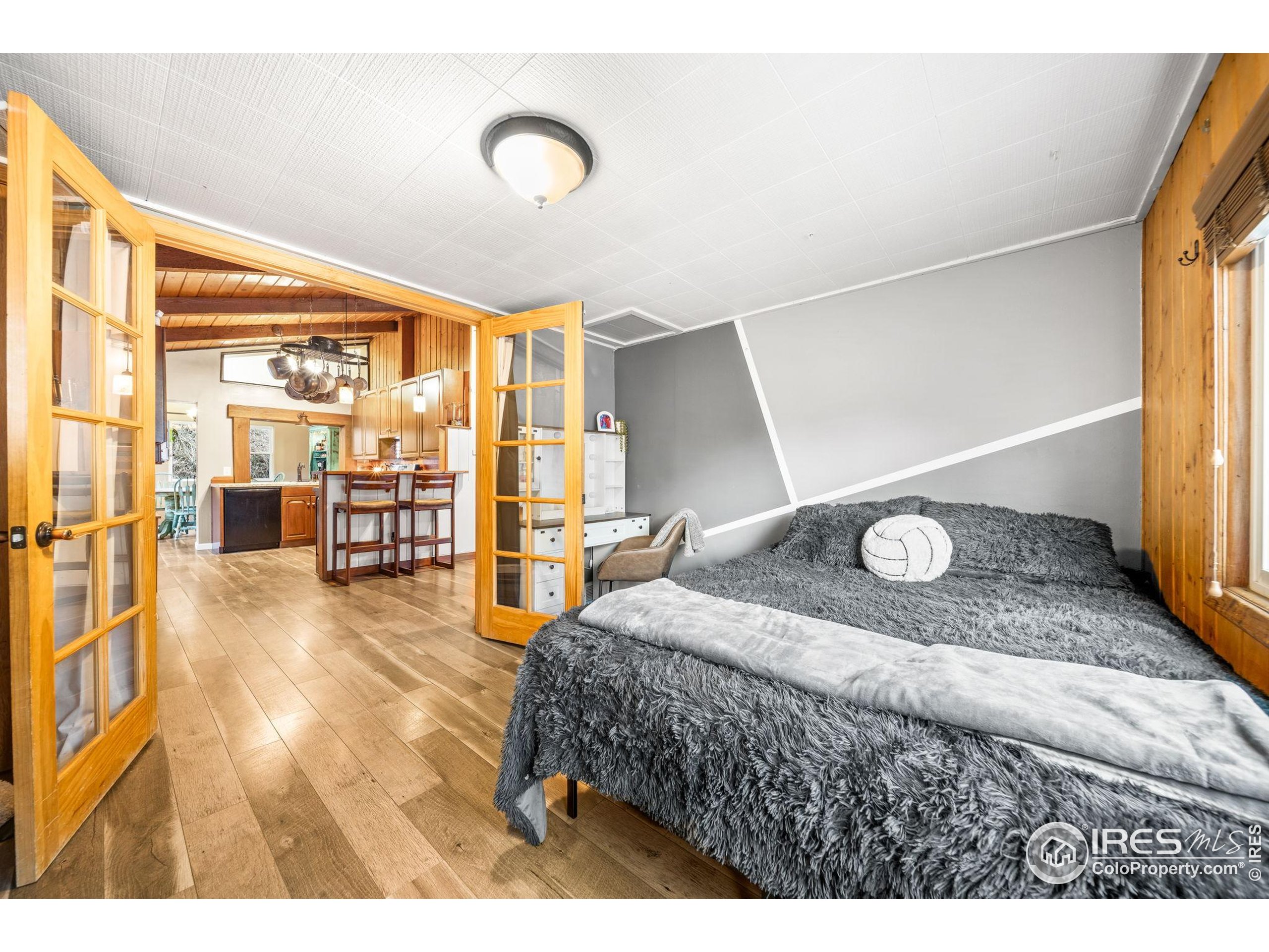 24 Tracy Trail Road Loveland, CO 80537 - Photo 17 of 34 a bedroom with a bed and glass wall painting