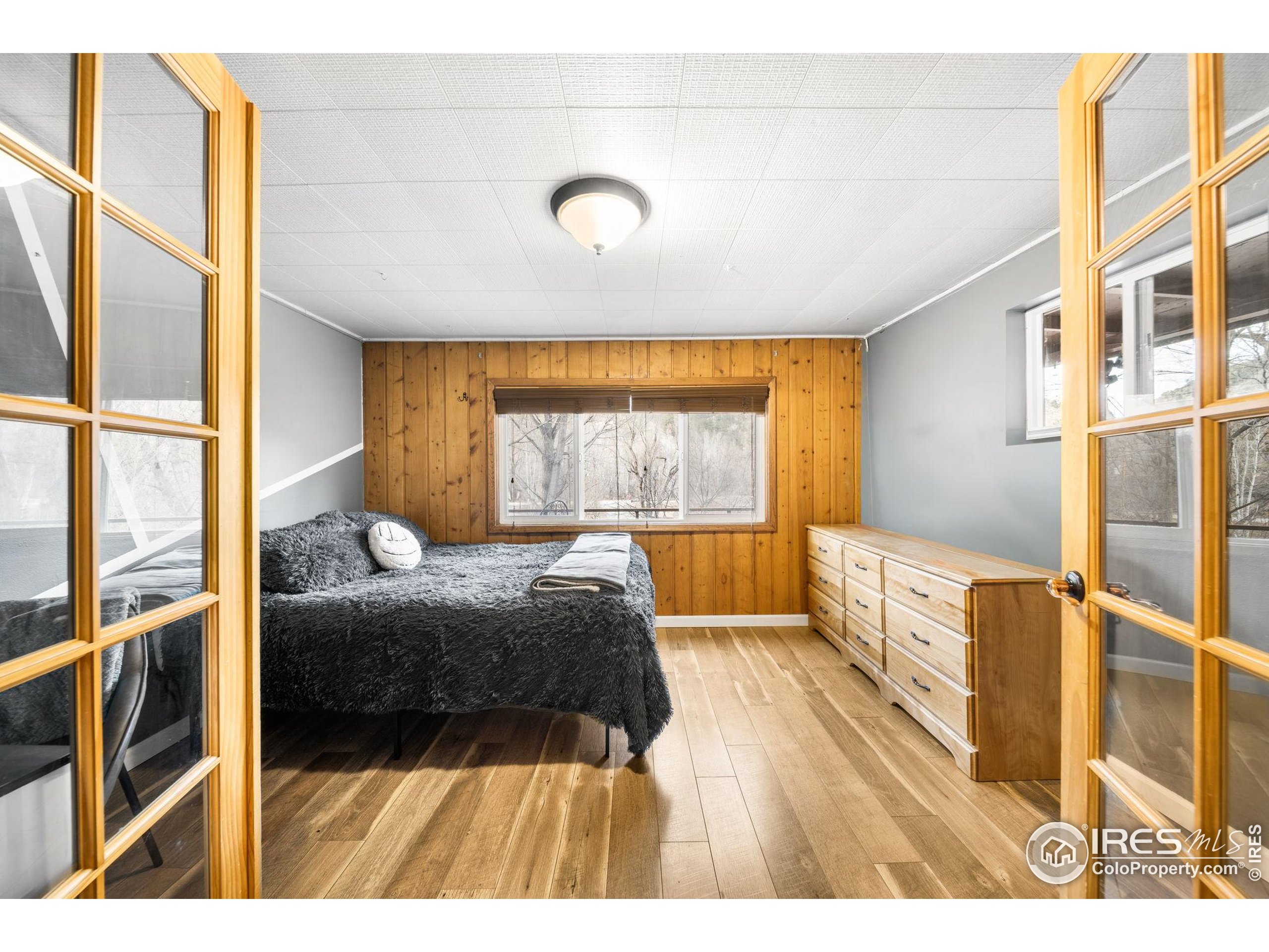 24 Tracy Trail Road Loveland, CO 80537 - Photo 18 of 34 a bedroom with a bed and a large window with outer view