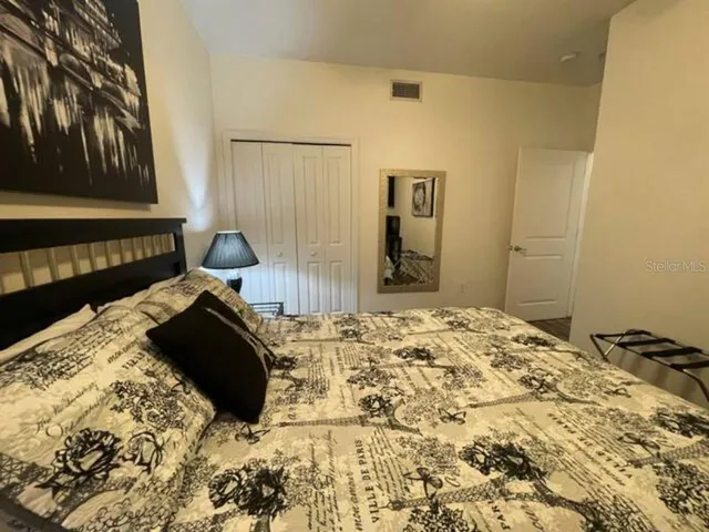 a bedroom with a bed and wooden floor