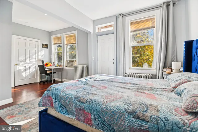 a bedroom with a bed and wooden floor