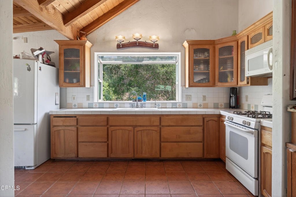 8416 Wheeler Canyon Road Santa Paula, CA 93060 - Photo 12 of 48 a kitchen with granite countertop a sink stainless steel appliances and cabinets