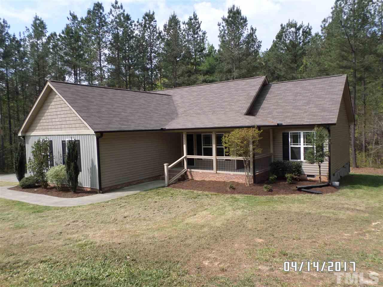 3993 Range Road Stem, NC 27581 - Photo 1 of 12 a front view of a house with a garden and porch