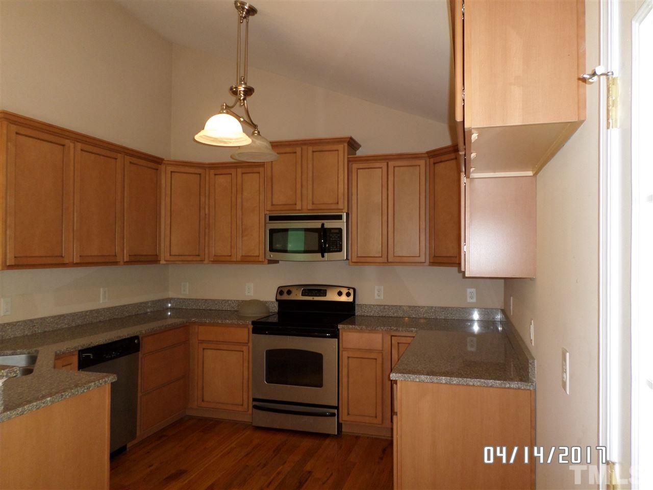 3993 Range Road Stem, NC 27581 - Photo 4 of 12 a kitchen with granite countertop a sink a stove and cabinets