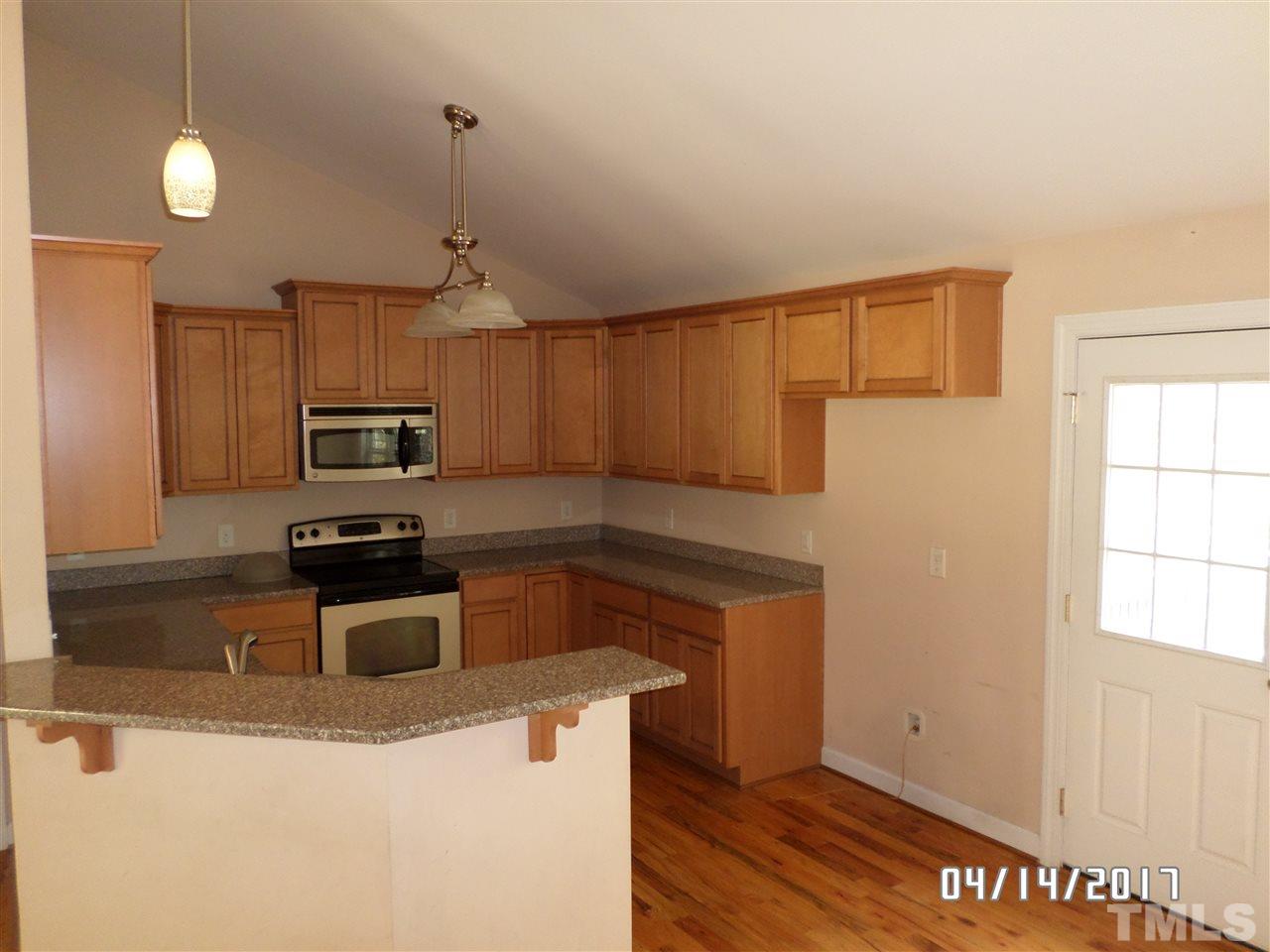 3993 Range Road Stem, NC 27581 - Photo 5 of 12 a kitchen with granite countertop a stove a sink and a microwave