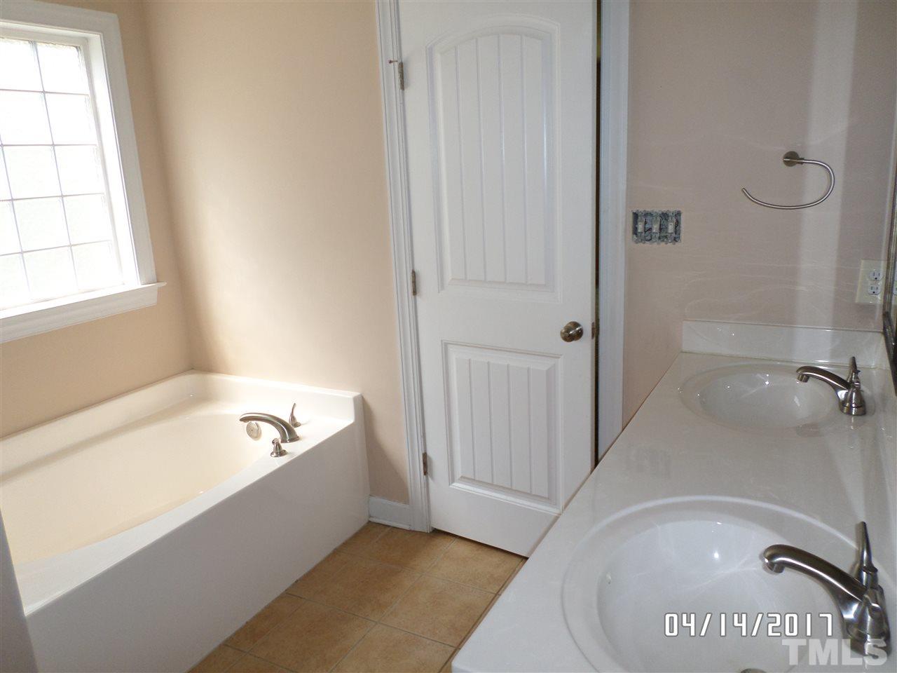 3993 Range Road Stem, NC 27581 - Photo 8 of 12 a bathroom with a tub a window and a shower