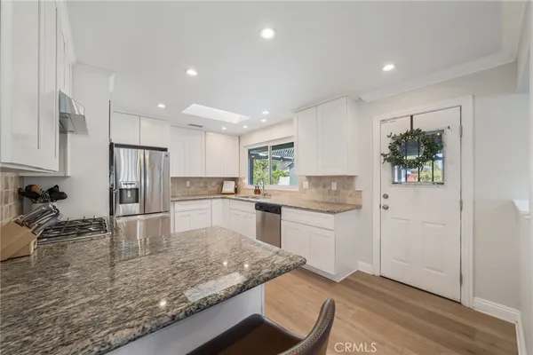 a kitchen with a refrigerator sink and wooden cabinets