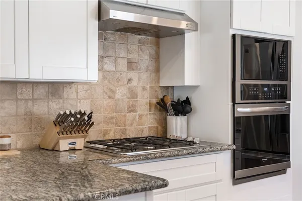 a kitchen with granite countertop a stove and a sink