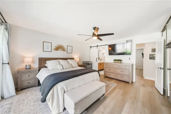a large bedroom with a bed and wooden floor