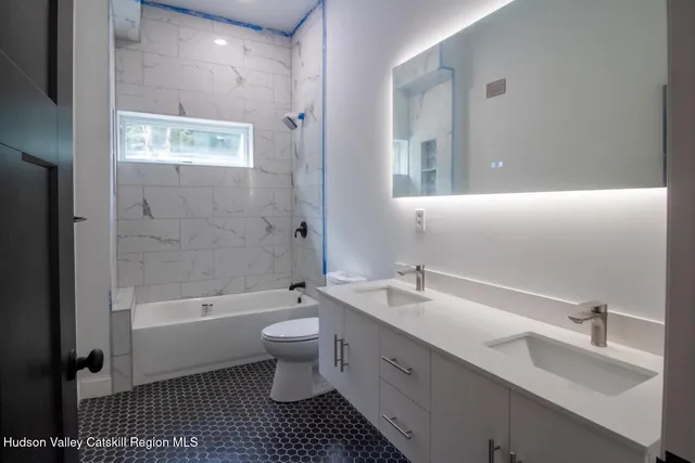 a bathroom with a double vanity sink toilet and shower