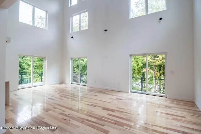 a view of a living room and kitchen with furniture wooden floor and windows
