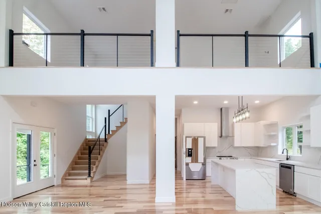 a view of a hallway with wooden floor and a kitchen