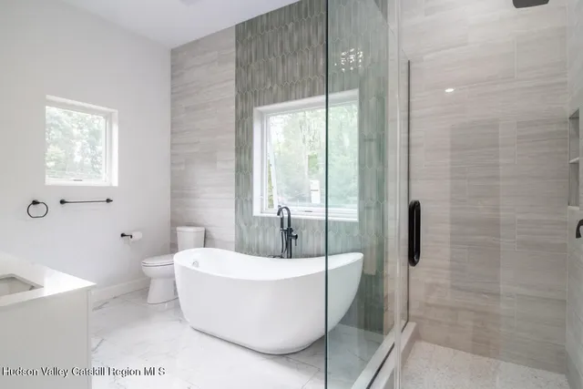 a white bath tub sitting next to a toilet