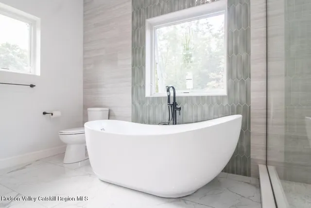 a white bath tub sitting next to a bathroom sink