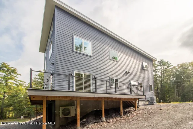 a view of a house with a backyard and chairs