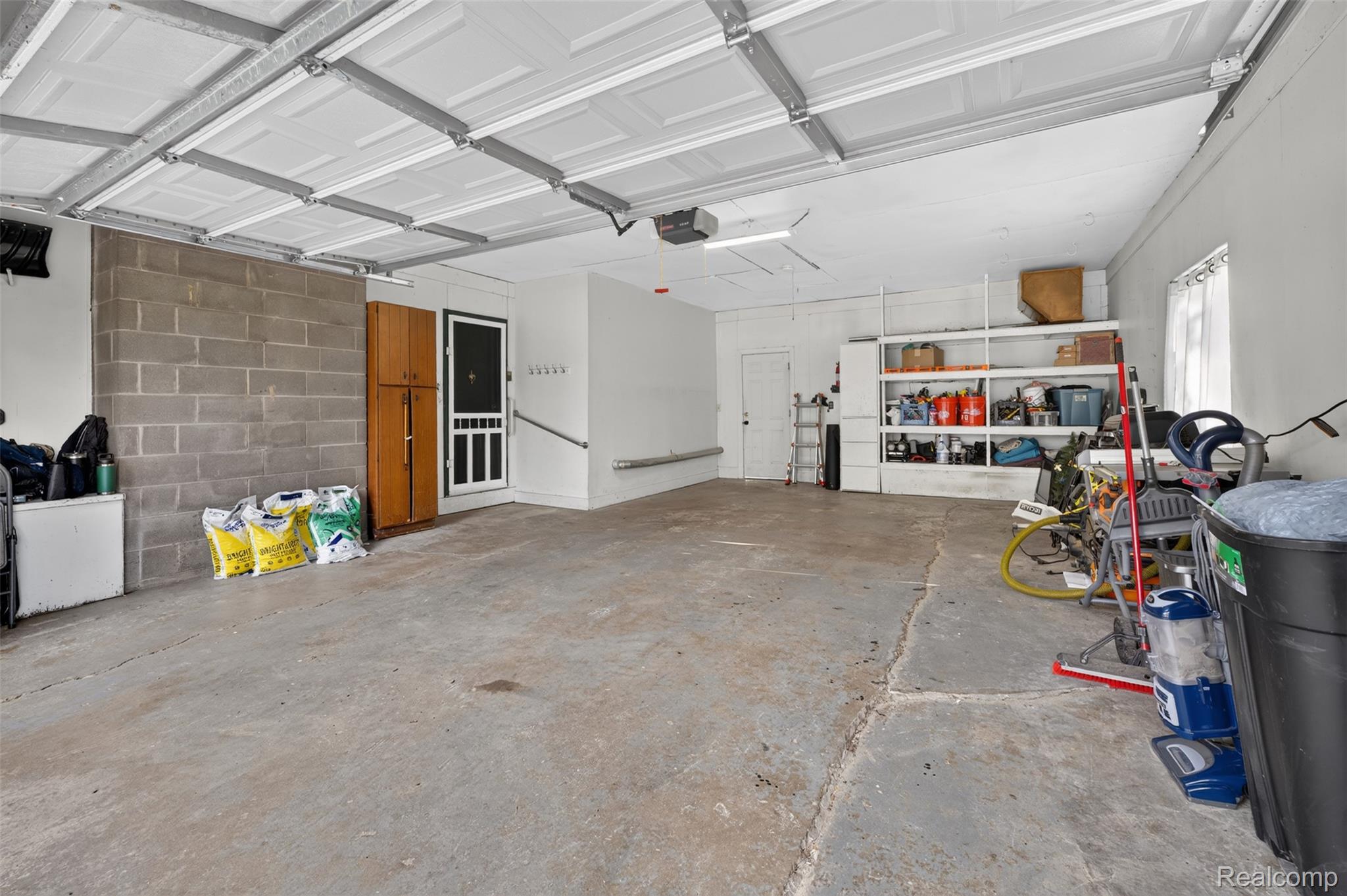 12055 West Pierson Road Flushing, MI 48433 - Photo 50 of 69 Concrete flooring with overhead lighting, white storage shelving, and a built-in cabinet