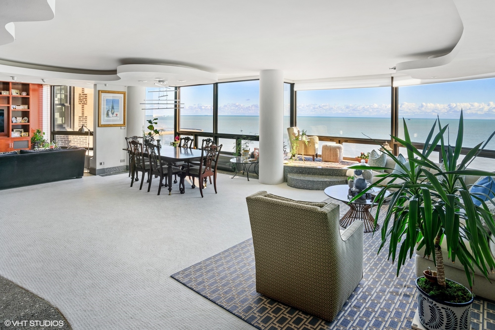 a dining room with furniture a potted plant and a rug
