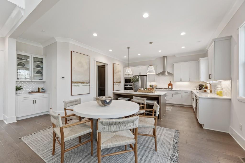 4510 Aiden Way Cumming, GA 30041 - Photo 13 of 53 a kitchen with a dining table chairs and white appliances