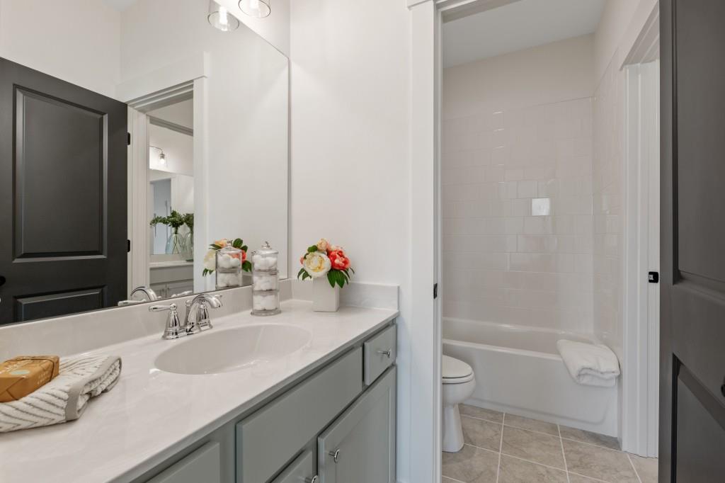 4510 Aiden Way Cumming, GA 30041 - Photo 25 of 53 a bathroom with a granite countertop sink toilet and shower