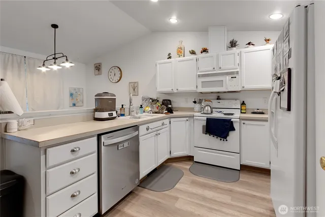 a kitchen with white cabinets stainless steel appliances and sink