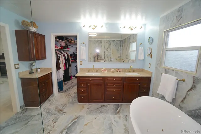 a bathroom with a sink vanity granite tub shower and a mirror