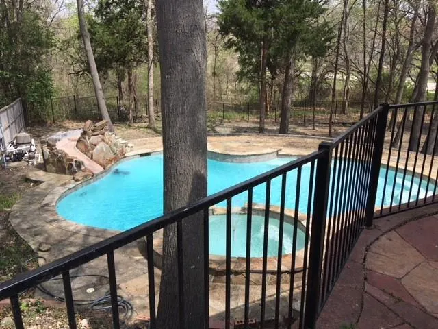 a view of a swimming pool with a patio and a yard