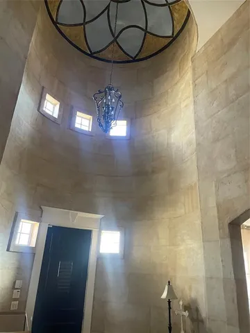 a view of empty room with window and chandelier fan