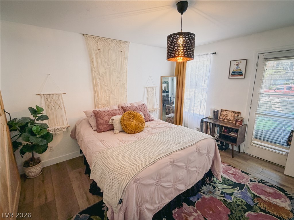 701 Capri Drive, Unit 20A Boulder City, NV 89005 - Photo 9 of 21 Hardwood floors and a charming overhead light fixture define this cozy bedroom space.