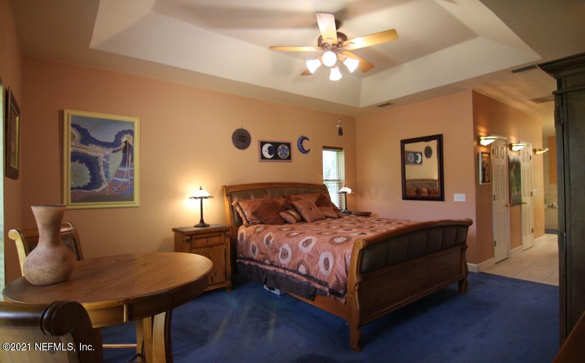 1365 Highway 206 St. Augustine, FL 32086 - Photo 23 of 54 a bedroom with a bed chandelier and a window